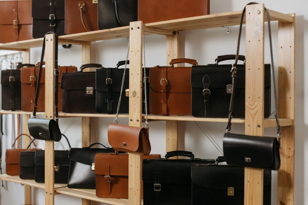 a picture of shelves of purses, handbags, and briefcases, waiting for embossing for personalization.